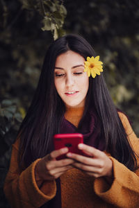 Portrait of beautiful young woman using smart phone outdoors