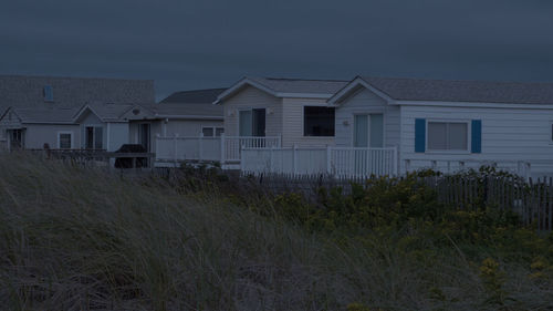 Houses on field against sky at dusk