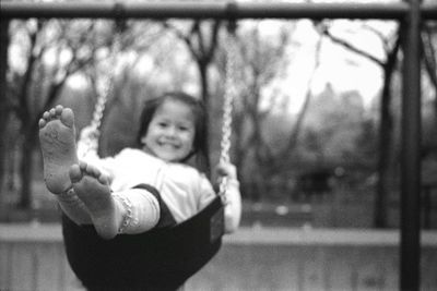 Close-up portrait of smiling girl by tree