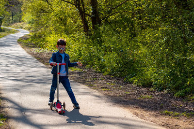 Rear view of boy on road by footpath