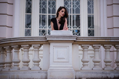 Portrait of woman standing against building