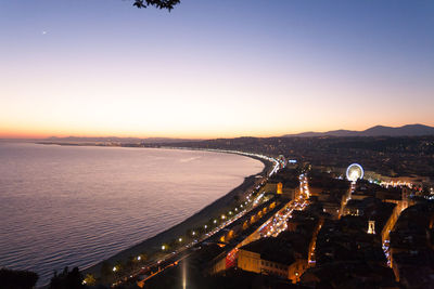 Aerial view of city lit up at sunset