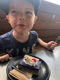 Portrait of boy with ice cream on table