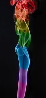 Close-up of multi colored light painting against black background