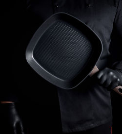 Midsection of man holding empty cooking pan