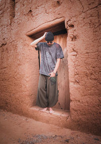 Full length of man standing against wall