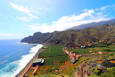 Scenic view of sea and mountains against sky