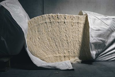 Close-up of paper relaxing on bed against white wall