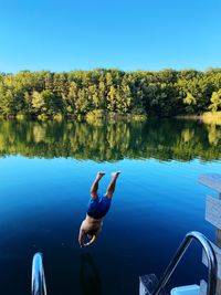 High angle view of man dives into lake against sky