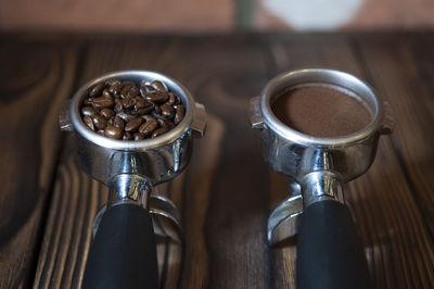 Close-up of ground coffee and roasted coffee beans in filters on table