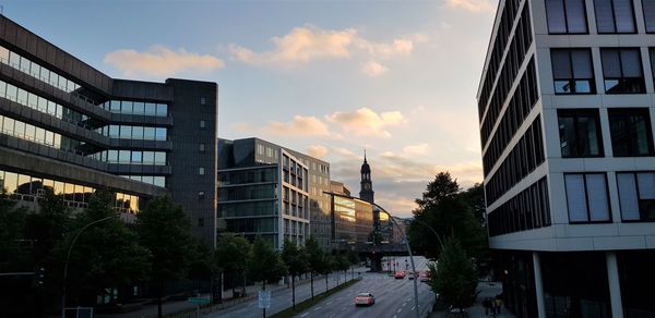 Street amidst buildings against sky during sunset