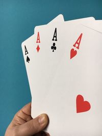 Cropped image of hand with aces cards at casino table