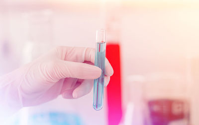 Close-up of hand holding chemical in test tube