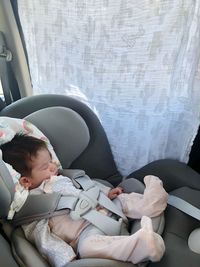 Full length of baby girl sleeping on vehicle seat in car