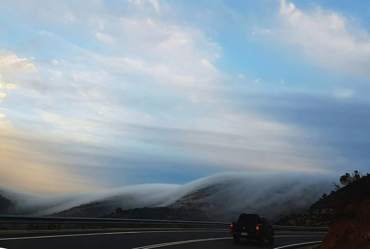 SCENIC VIEW OF MOUNTAINS AGAINST CLOUDY SKY AT SUNSET