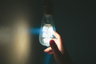 Close-up of hand holding light bulb