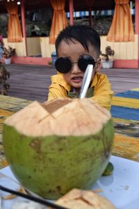 Portrait of boy holding food on table