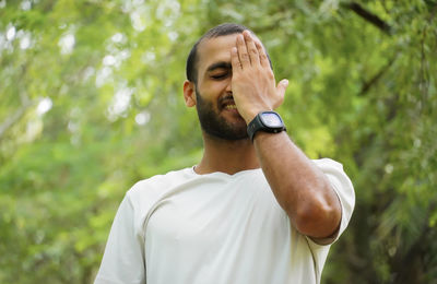 Side view of man standing against trees