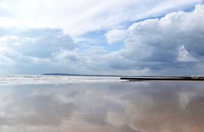 Scenic view of calm sea against cloudy sky