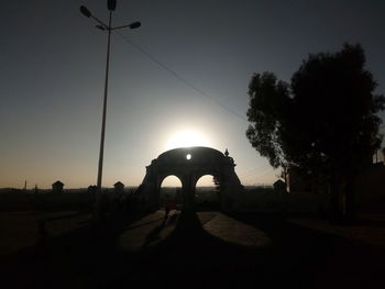 Silhouette of street light against clear sky