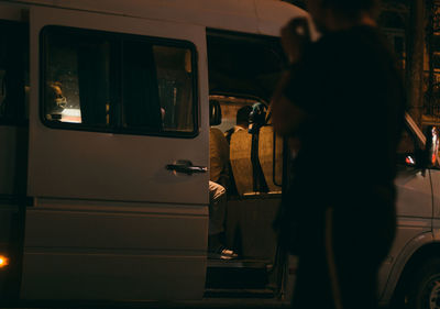 Silhouette people standing by bus in city