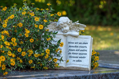 Close-up of flower statue against trees