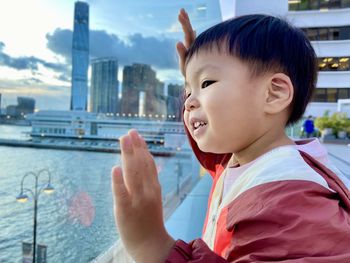 Close-up of boy looking away against buildings