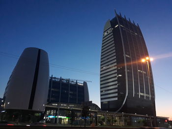 Low angle view of illuminated buildings against sky in city
