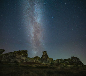 Low angle view of rock formation against sky at night