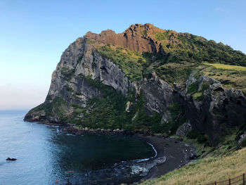 Scenic view of rock formation in sea against clear sky