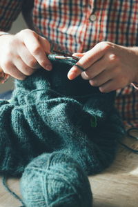 Close up of human hands knitting at home