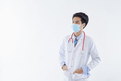 Portrait of young man standing against white background