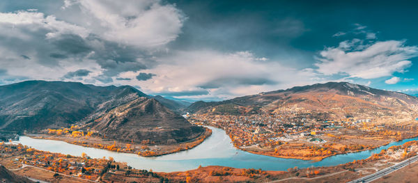 Aerial view of townscape against cloudy sky