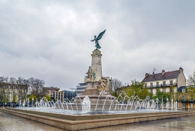 Statue of historic building against cloudy sky