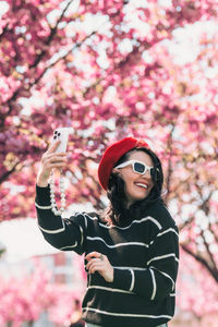 Portrait of young woman standing against trees