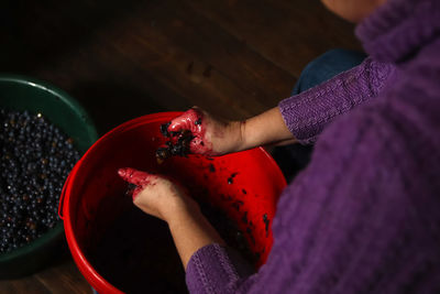 Woman making wine. female hands holding crushed grapes. wine-making process. harvest home. 