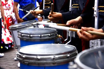 Midsection of musicians playing drums at music concert