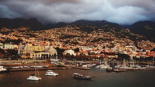 Aerial view of townscape by sea against sky