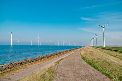 Wind turbines on land against sky