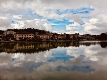 Scenic view of lake by buildings against sky