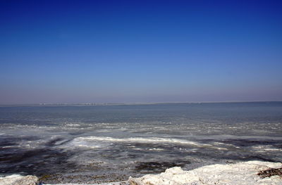 Scenic view of sea against clear blue sky