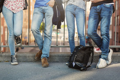 Low section of teenagers standing on bridge