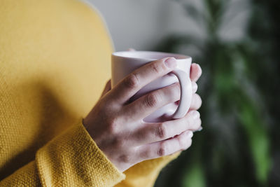 Close-up of hand holding coffee cup