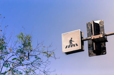 Low angle view of road sign against clear blue sky