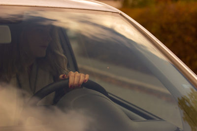 Low section of woman in car window