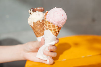 Cropped image of hands holding ice creams in waffles