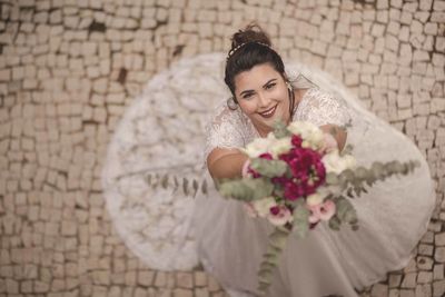 Portrait of young woman against brick wall