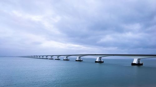 Bridge over sea against sky