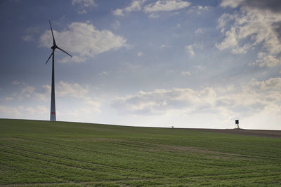 Windmill on field against sky