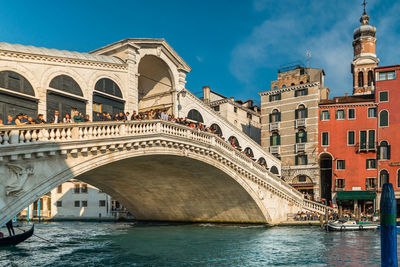 Arch bridge over river against buildings in city